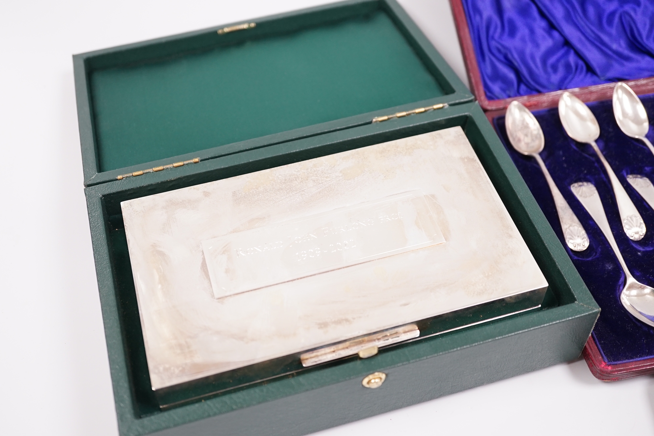 A cased George V silver christening trio, two cased sets of silver teaspoons, including set of twelve with sugar tongs and a cased modern silver mounted presentation cigarette box.